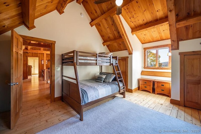 bedroom featuring light wood-style floors, wood ceiling, and beamed ceiling