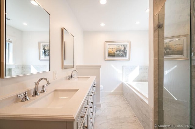 full bath featuring double vanity, a sink, a bath, and baseboards