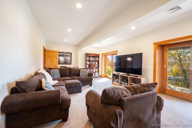 living room featuring a healthy amount of sunlight, visible vents, and light carpet