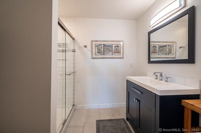 bathroom with vanity and a shower with door