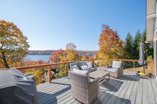 wooden deck featuring an outdoor living space and a water view