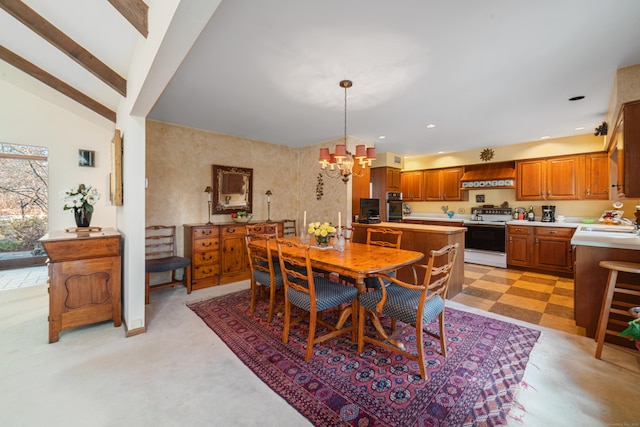 carpeted dining room featuring a chandelier, sink, and high vaulted ceiling