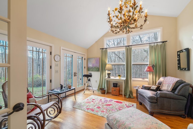 sitting room with a healthy amount of sunlight, an inviting chandelier, and hardwood / wood-style flooring