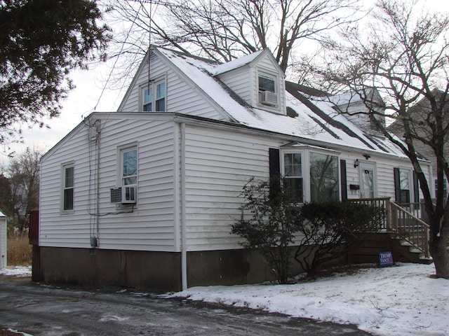 view of snow covered exterior featuring cooling unit