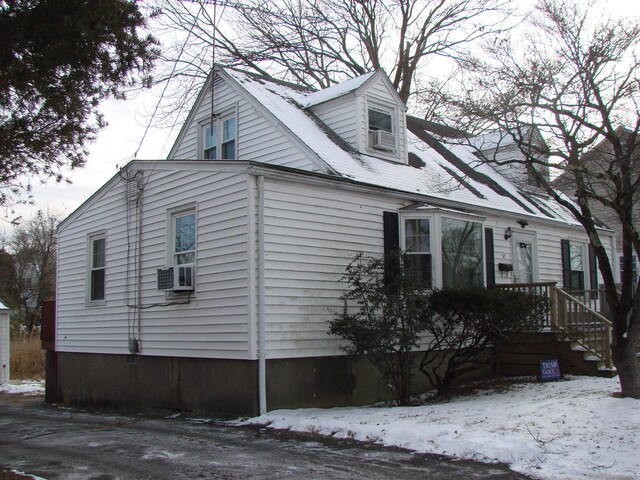 view of snow covered exterior with cooling unit