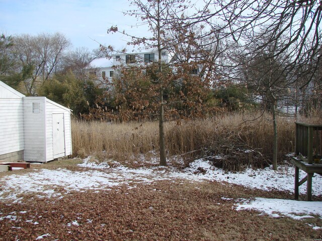 yard covered in snow featuring a storage shed