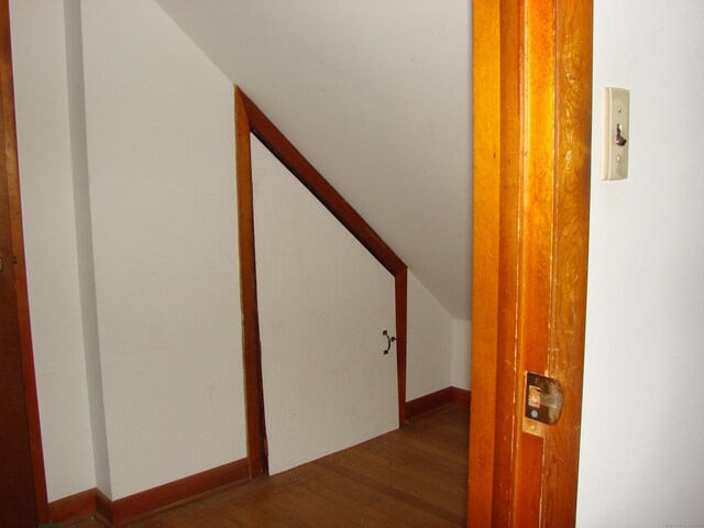 hall featuring lofted ceiling and dark hardwood / wood-style floors