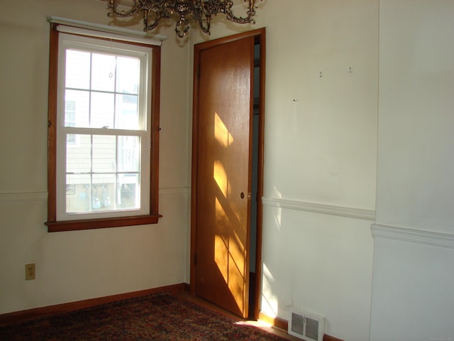 doorway to outside with an inviting chandelier