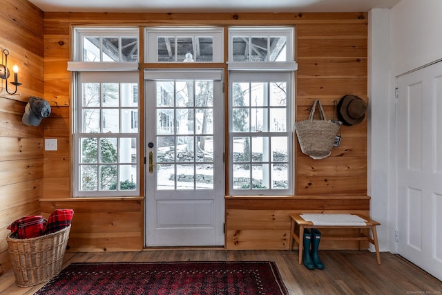 doorway to outside featuring wooden walls and hardwood / wood-style flooring