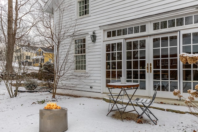 snow covered property entrance with french doors