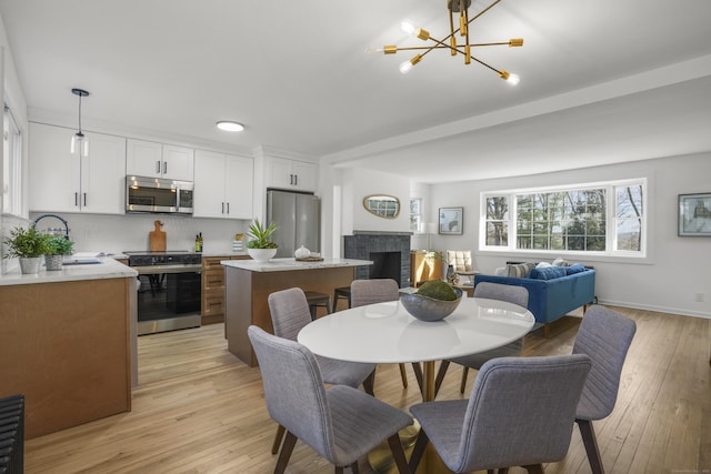 dining space featuring a notable chandelier, light hardwood / wood-style floors, and sink