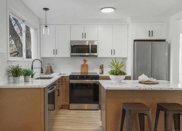 kitchen with light stone counters, white cabinets, decorative backsplash, and appliances with stainless steel finishes