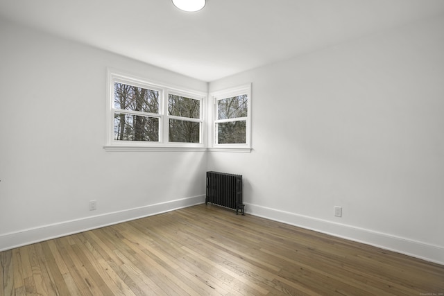 empty room with light hardwood / wood-style floors and radiator