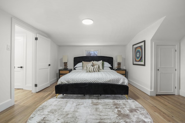 bedroom featuring vaulted ceiling and light wood-type flooring