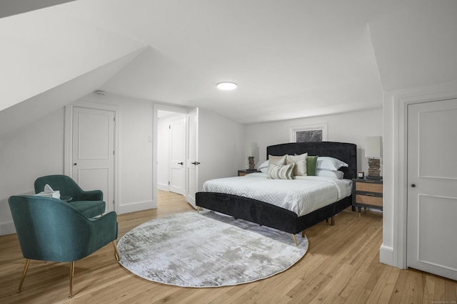 bedroom featuring vaulted ceiling and light hardwood / wood-style floors