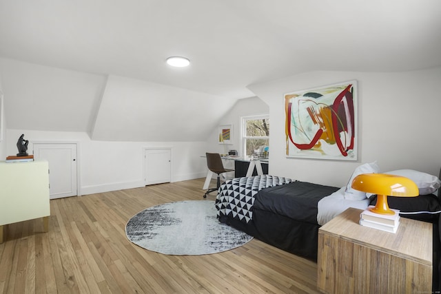 bedroom with lofted ceiling and light hardwood / wood-style floors