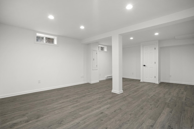 basement with baseboard heating and dark hardwood / wood-style flooring