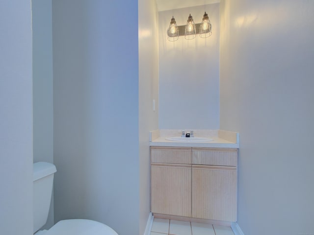 bathroom with toilet, vanity, and tile patterned floors