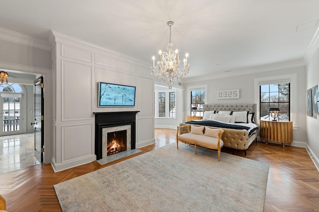 bedroom featuring crown molding, light parquet flooring, a premium fireplace, and a chandelier