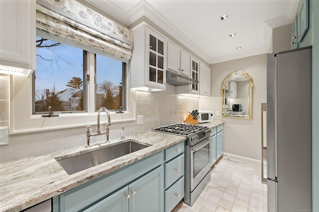 kitchen with sink, stainless steel appliances, ornamental molding, white cabinets, and decorative backsplash