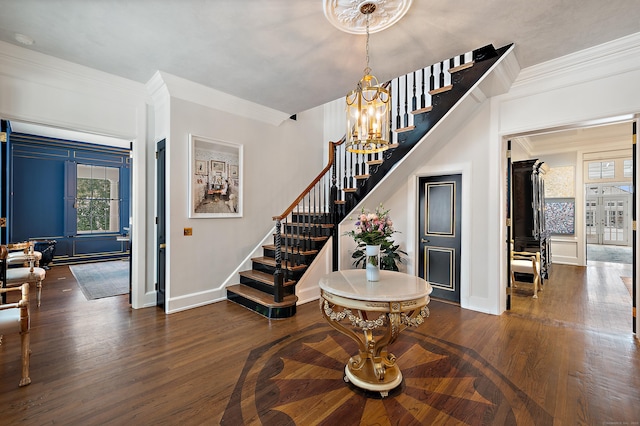 foyer entrance with baseboards, ornamental molding, wood finished floors, and stairway