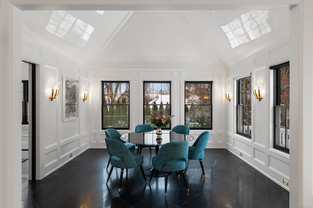 dining space with crown molding, high vaulted ceiling, and a decorative wall