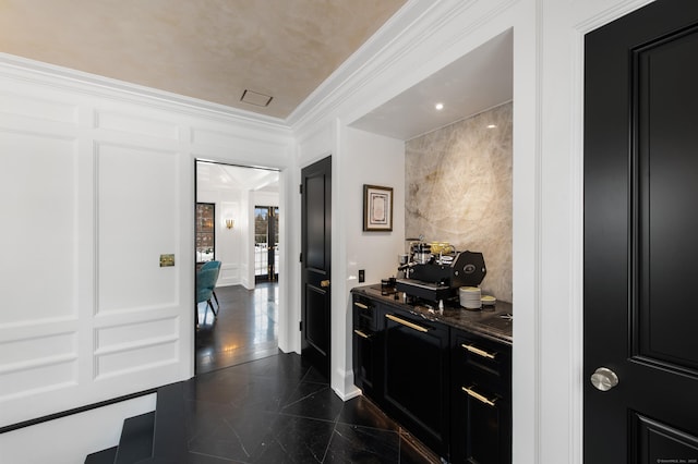 hall featuring ornamental molding, a decorative wall, and granite finish floor