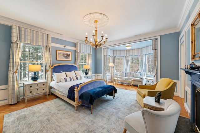 bedroom featuring an inviting chandelier, ornamental molding, wainscoting, and multiple windows