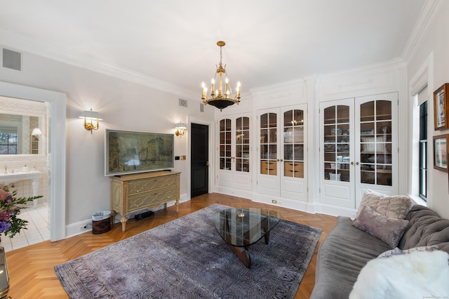 living room with crown molding, baseboards, visible vents, and an inviting chandelier