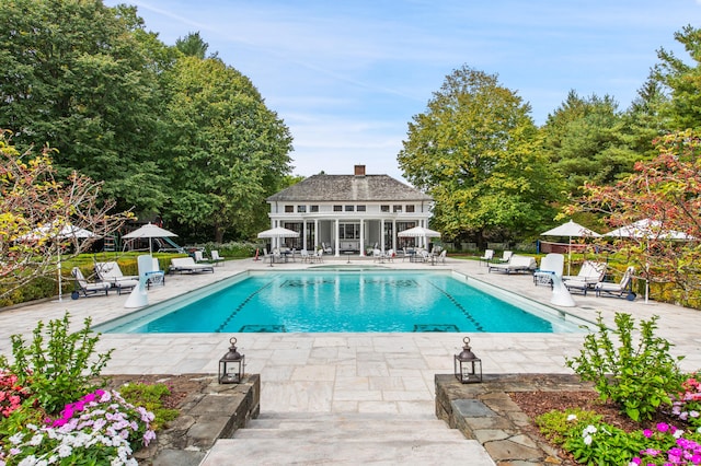 pool featuring fence, a patio, an outdoor structure, and an exterior structure