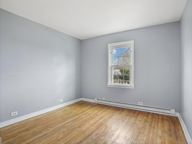 spare room with a baseboard heating unit and light hardwood / wood-style flooring