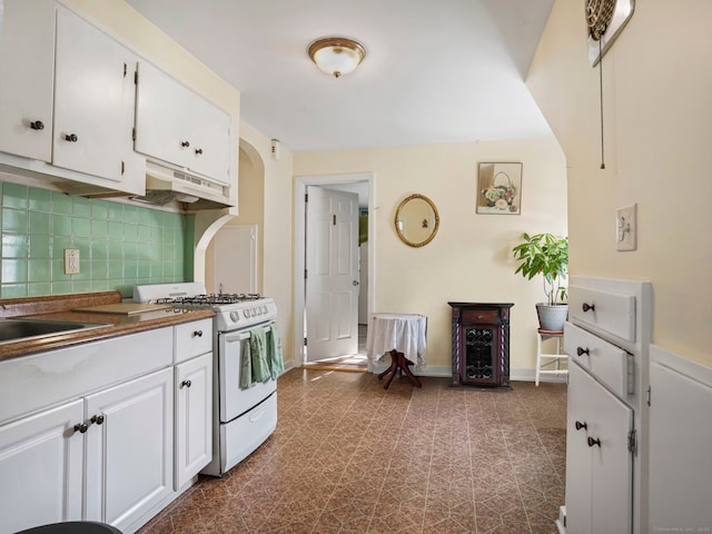 kitchen with sink, white cabinets, backsplash, and gas range gas stove