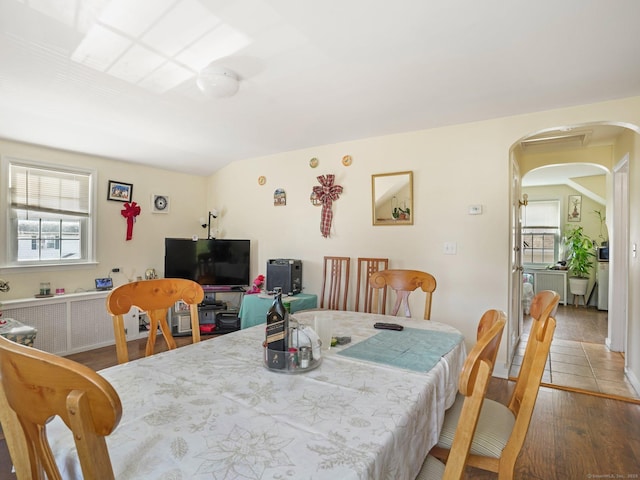 dining area with hardwood / wood-style flooring and radiator heating unit