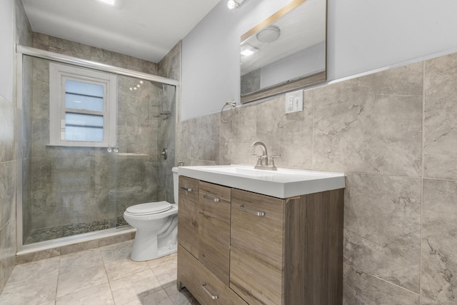 bathroom with tile walls, toilet, vanity, and walk in shower