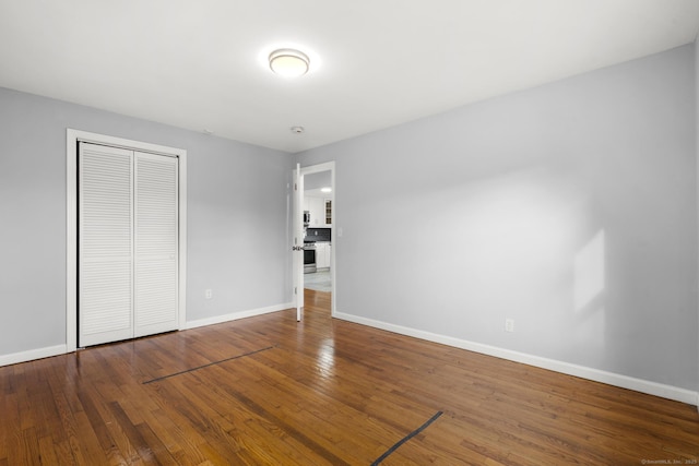 unfurnished bedroom featuring a closet and hardwood / wood-style flooring