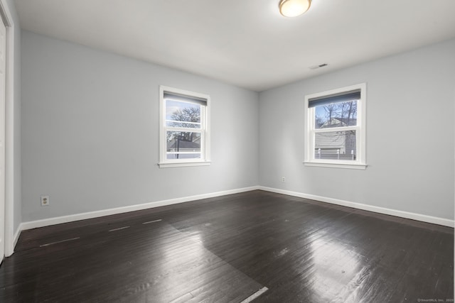 spare room featuring dark hardwood / wood-style floors and a wealth of natural light