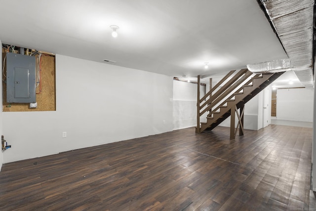 basement featuring dark wood-type flooring and electric panel