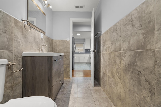 bathroom with tile walls, tile patterned floors, and vanity