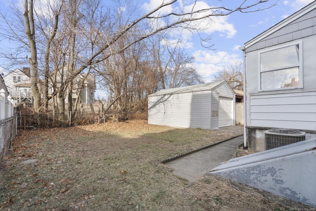 view of yard with an outbuilding, central AC, and a garage