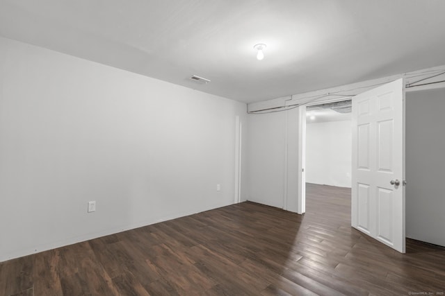 unfurnished bedroom with dark wood-type flooring and a closet