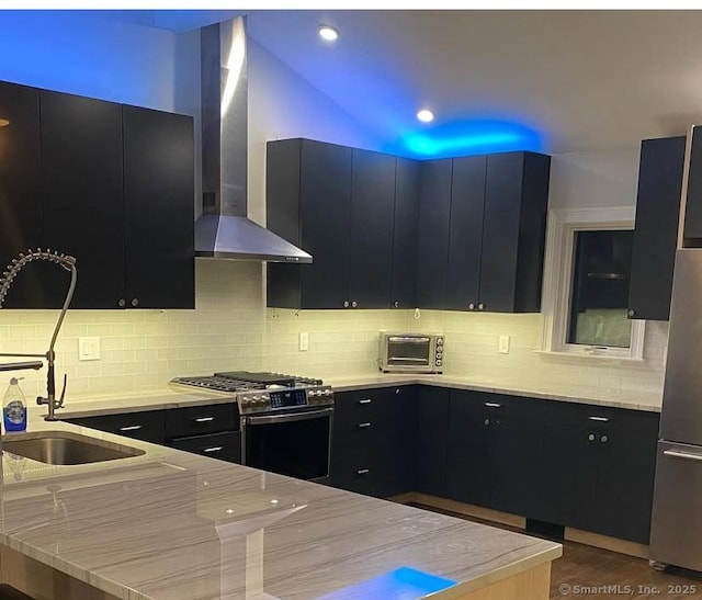 kitchen with appliances with stainless steel finishes, wall chimney exhaust hood, dark wood-type flooring, decorative backsplash, and sink