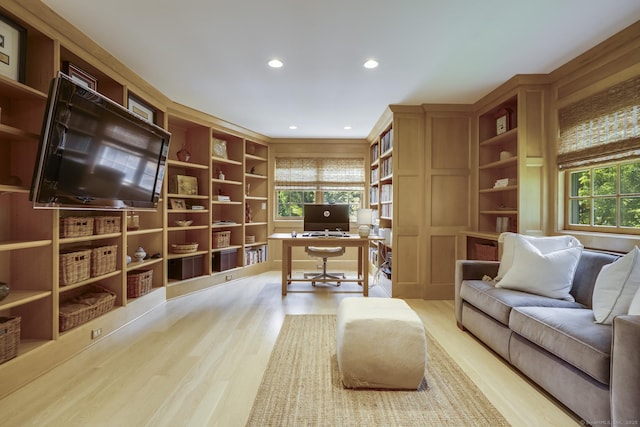 office space with light wood-type flooring, a wealth of natural light, and built in shelves