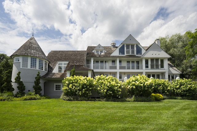 rear view of property featuring a lawn