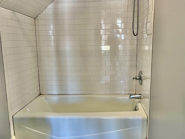 bathroom with vaulted ceiling and tiled shower / bath combo