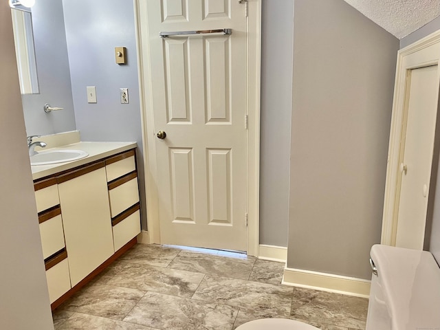 bathroom with lofted ceiling, vanity, toilet, and a textured ceiling