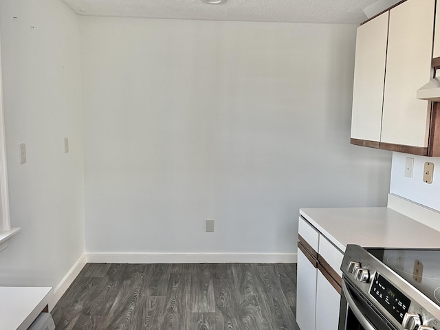 kitchen with electric stove, dark hardwood / wood-style floors, white cabinetry, and a textured ceiling