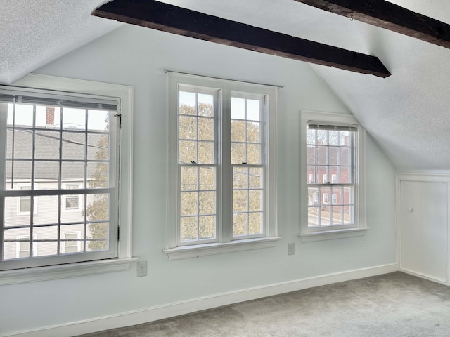 additional living space featuring carpet floors, lofted ceiling with beams, and a textured ceiling