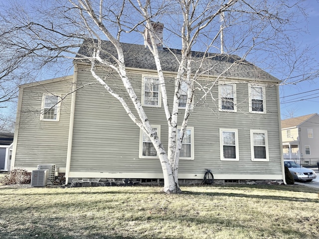 view of property exterior with central air condition unit and a yard