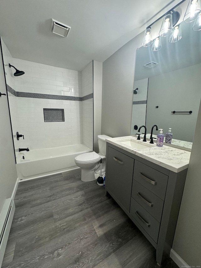 bathroom with toilet, shower / bath combination, wood finished floors, a baseboard radiator, and vanity