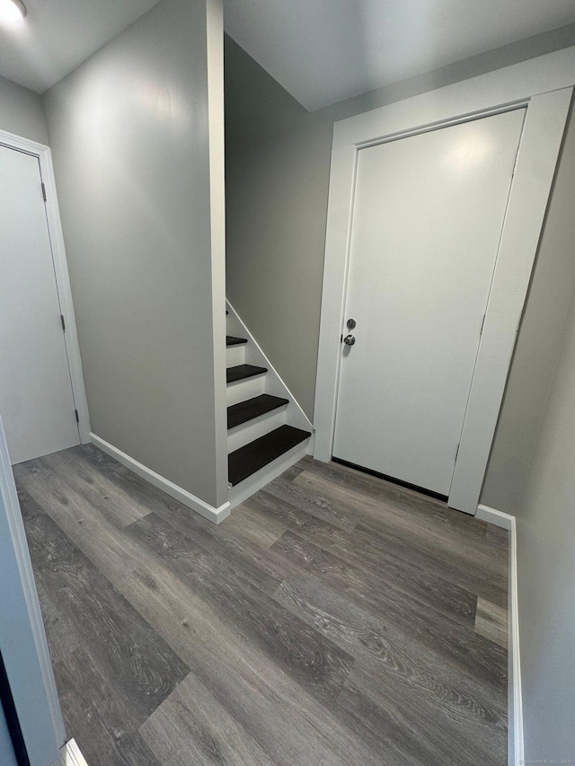 foyer entrance featuring stairs, baseboards, and wood finished floors